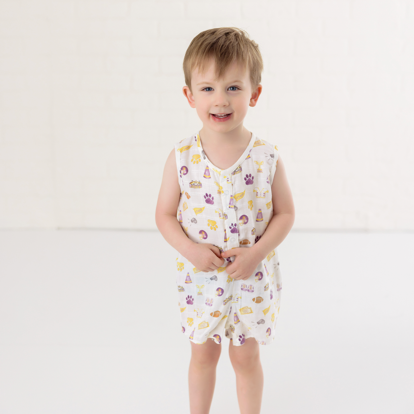 Baby wearing Let's go Tigers organic muslin shortall with tiger print and snap closures