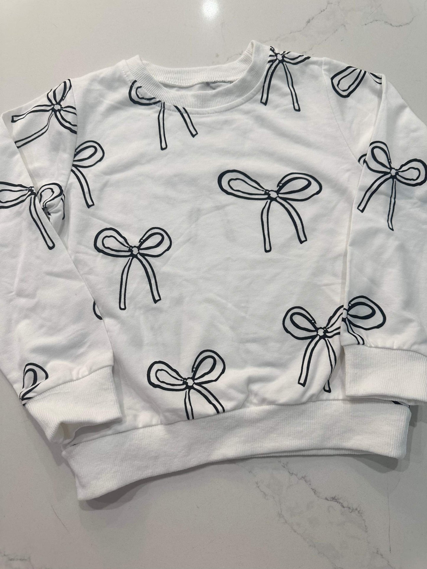 White sweatshirt with black bow print design in monochrome style