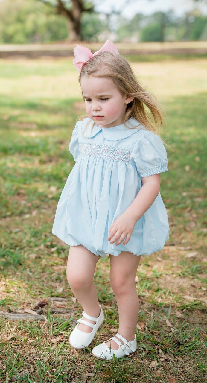 Blair Girl Bubble aqua dress with pink smocked detailing on toddler girl outdoors