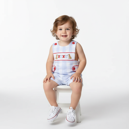 toddler boy wearing SMOCKED BOYS XOXO DOG shortall with blue check pattern and red buttons sitting on white stool