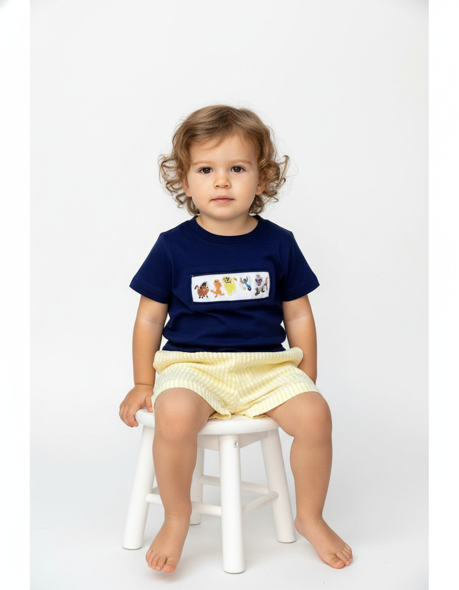 Lion hand smocked boy short set with navy top and yellow striped seersucker bottom featuring animal patterns